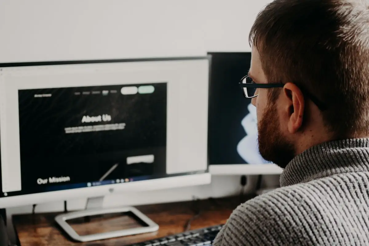 Web developer working on a business website across dual monitors