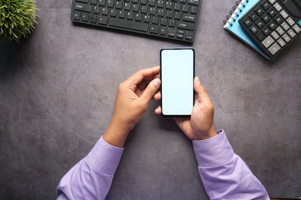 Business owner planning a mobile app budget with notes and calculator