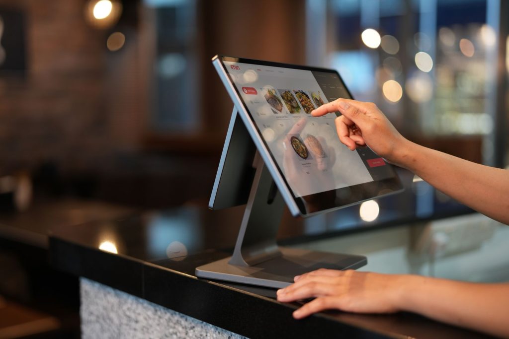 Cashier using a touchscreen POS system in a UAE retail store